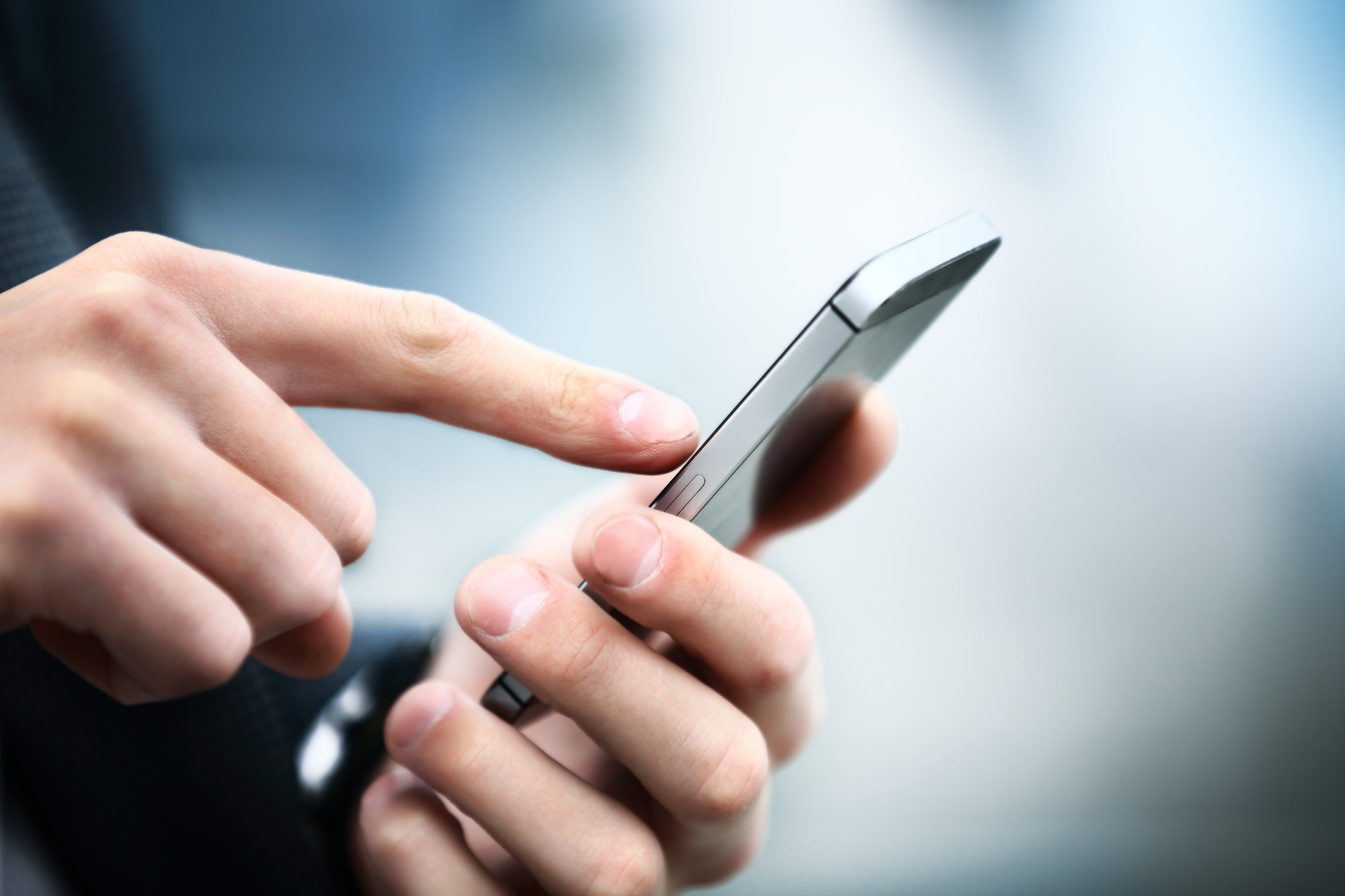 A Person placing a finger on a silver iphone