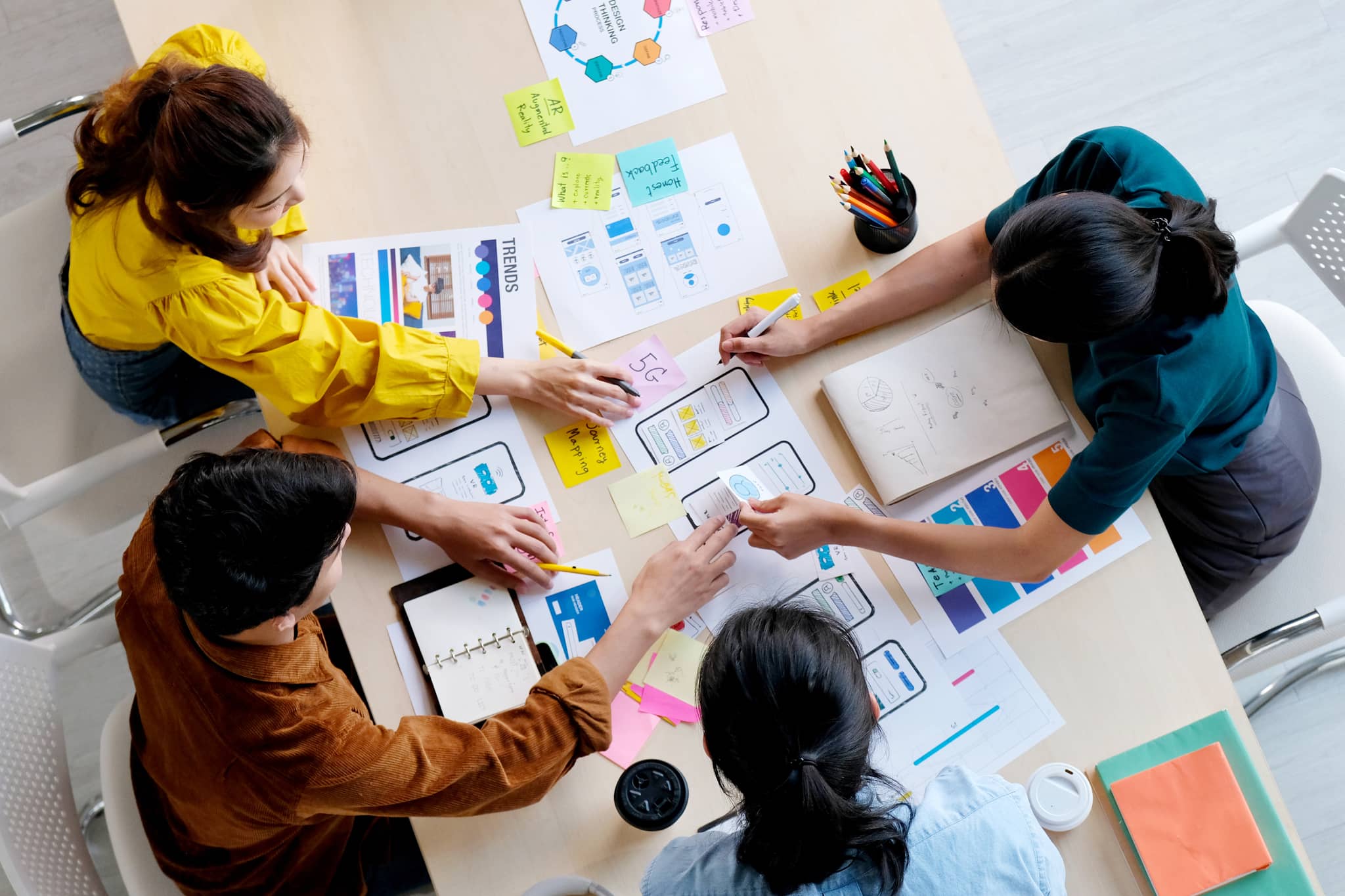 People working over a desk looking at UX