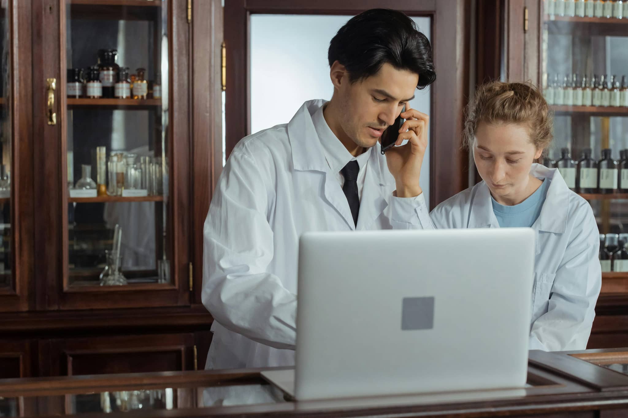 Pharmaceutical Software Development Use In Action, Two Pharmacists Attempting to Solve a Problem on the Laptop