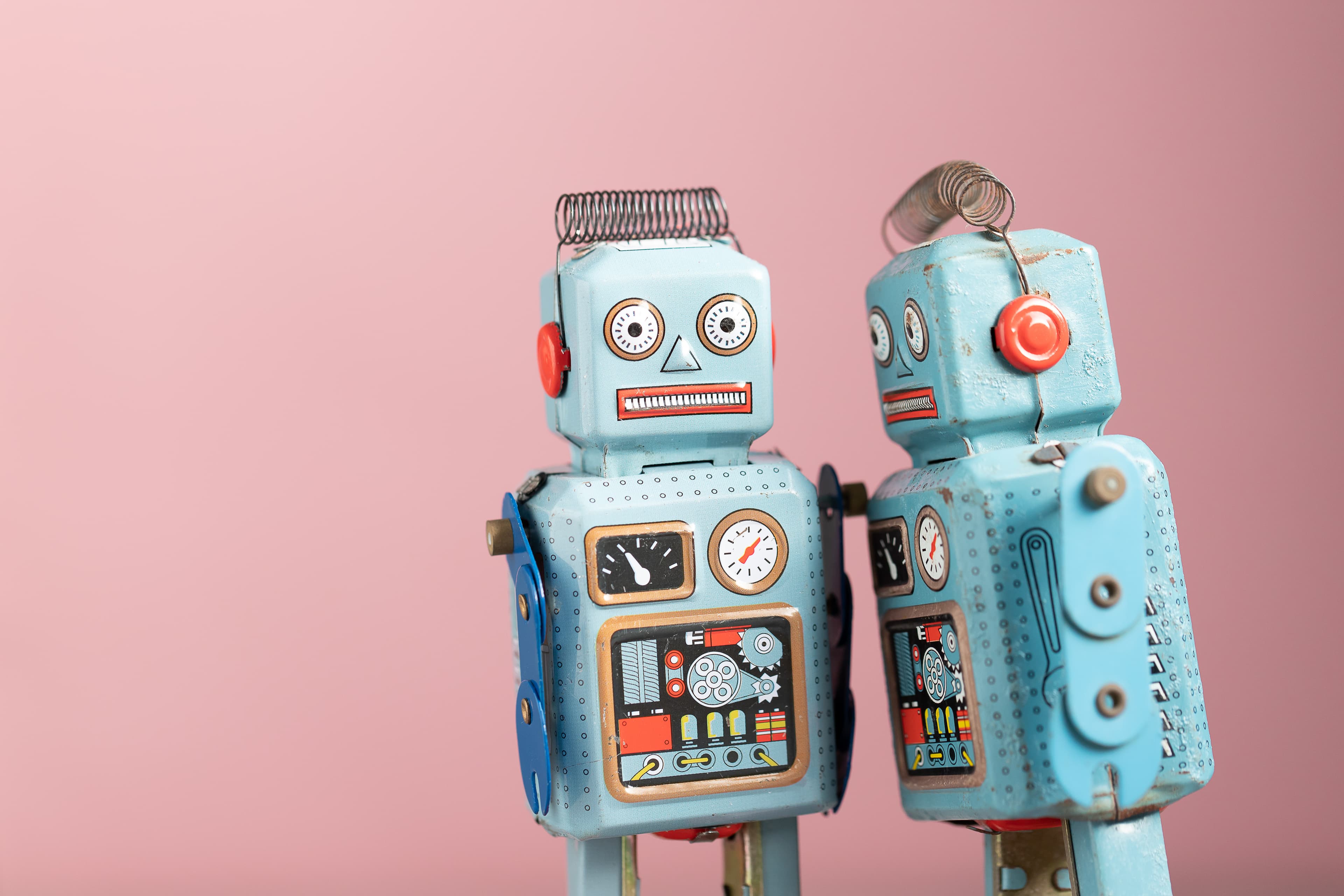 Two robots on a pink background
